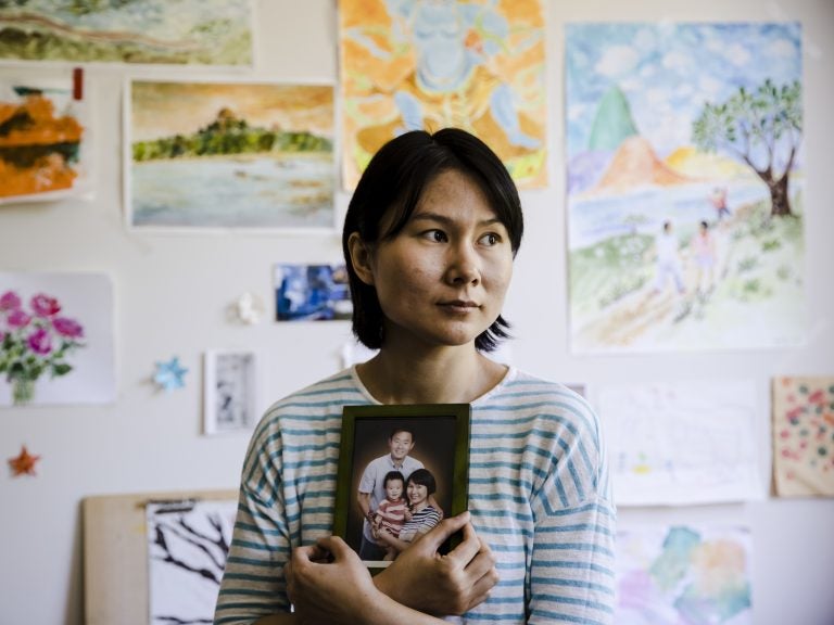 Hua Qu, the wife of Chinese-American Xiyue Wang, poses with a portrait of her family in Princeton, N.J., on May 9. Families of Americans detained in Iran are hoping President Trump’s decision to withdraw from the Iran nuclear deal will not make it harder to get their love ones freed. Hua Qu, the wife of Chinese-American Xiyue Wang, poses with a portrait of her family in Princeton, N.J., on May 9. Families of Americans detained in Iran are hoping President Trump's decision to withdraw from the Iran nuclear deal will not make it harder to get their love ones freed. (Matt Rourke/AP)