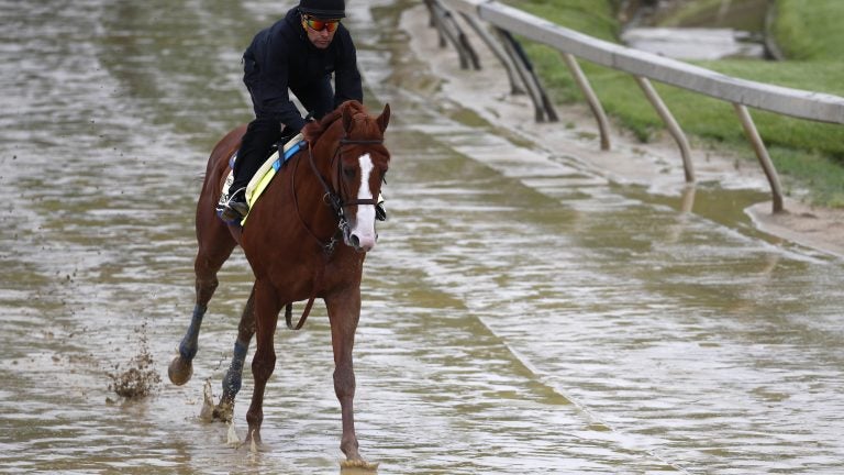 
Kentucky Derby winner Justify, with exercise rider Humberto Gomez aboard, gallops around the track Thursday at Pimlico Race Course in Baltimore. The Preakness Stakes is scheduled to take place Saturday and Justify is the favorite. (Patrick Semansky/AP) 