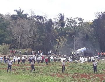 First responders and law enforcement gather in the field where an airliner crashed after takeoff Friday, just outside the international airport in Havana, Cuba. (Andrea Rodriguez/AP)