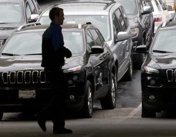 A worker on a Chrysler car lot passes lines of Jeeps in 2014. The House on Tuesday passed a measure to roll back guidance on auto lending issued by the Consumer Financial Protection Bureau. (Gregory Bull/AP)