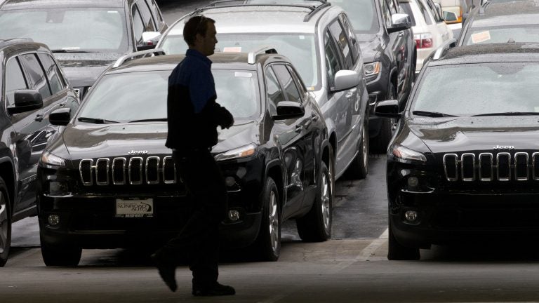 A worker on a Chrysler car lot passes lines of Jeeps in 2014. The House on Tuesday passed a measure to roll back guidance on auto lending issued by the Consumer Financial Protection Bureau. (Gregory Bull/AP)