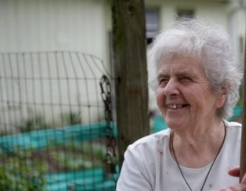 Sister Margaret McKenna rests next to her garden that helps supply the food pantry at New Jerusalem Now in North Philadelphia. (David Maialetti / Philly.com)