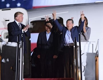 President Trump applauds as Kim Dong Chul (2nd R) gestures upon his return with Kim Hak Song (C) and Tony Kim (behind) after they were freed by North Korea, at Joint Base Andrews in Maryland.