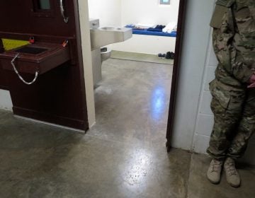 A U.S. military service member stands outside a prison cell at Camp 5. (Photo reviewed and cleared by U.S. military. David Welna/NPR)