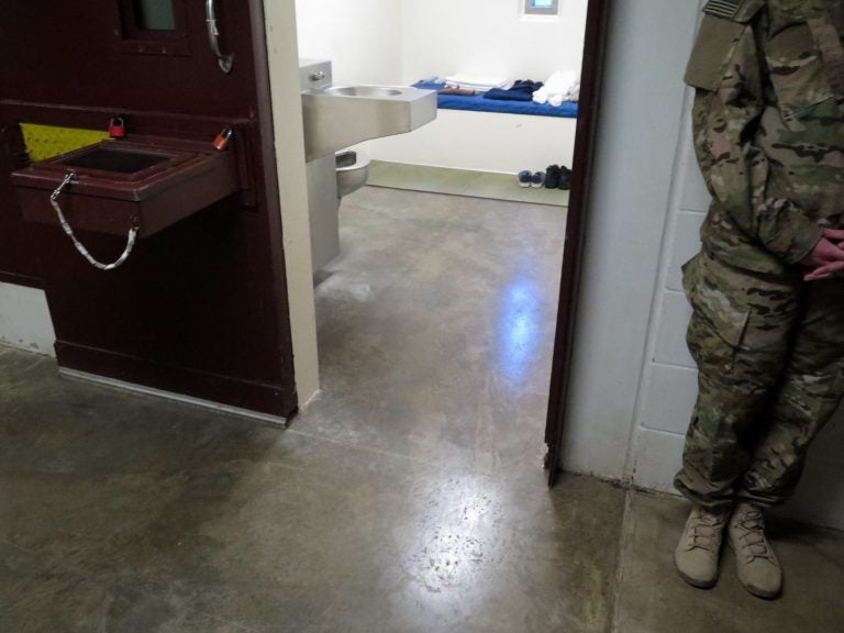 A U.S. military service member stands outside a prison cell at Camp 5. (Photo reviewed and cleared by U.S. military. David Welna/NPR)
