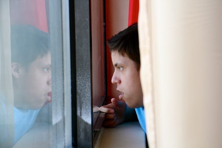 Luis Angel Chaparro Crespo, 16, watches the trains go by from the window of his apartment on the sixth floor of the Harrison Homes in North Philadelphia.