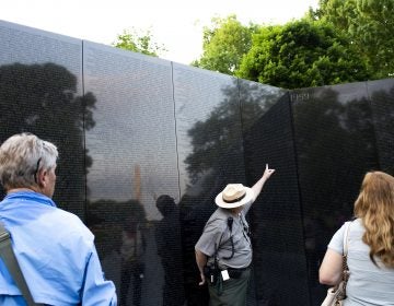 Robert Herendeen, National Park Service ranger, speaks to visitors at the Vietnam Veterans Memorial in Washington, D.C. Rangers like Herendeen have the task of collecting items left at the wall — including human remains. (Eslah Attar/NPR)