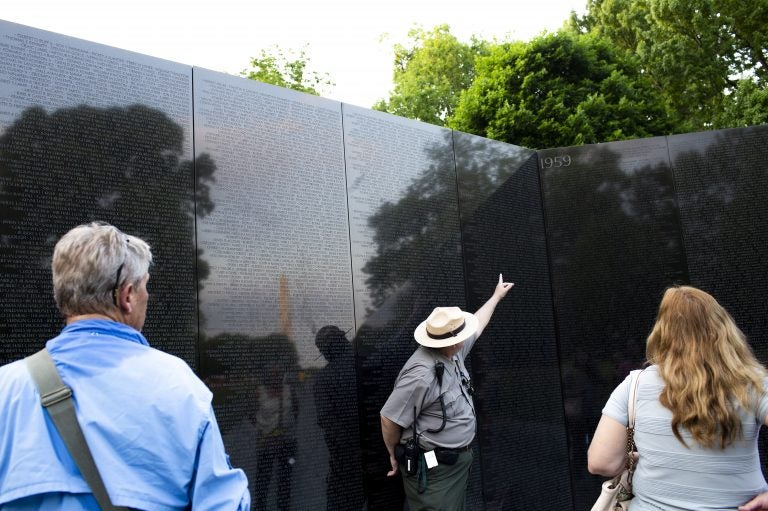 Robert Herendeen, National Park Service ranger, speaks to visitors at the Vietnam Veterans Memorial in Washington, D.C. Rangers like Herendeen have the task of collecting items left at the wall — including human remains. (Eslah Attar/NPR)