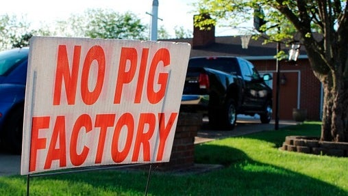 In this May 21, 2018 photo, a sign opposing an industrial hog farm is displayed at a home in Berwick, Pa. Residents who complain about foul smells from the nearby hog farm have taken their fight to the Pennsylvania Supreme Court. (Michael Rubinkam/AP Photo)