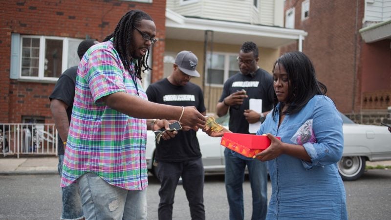 Tanya Parnell, or Miss Tee as the neighborhood kids call her, sells buttons with a photograph of Sandrea Williams and “#JusticeforSandrea” written on it. The proceeds will go directly to the 17-year-old’s family. (Emily Cohen for WHYY)