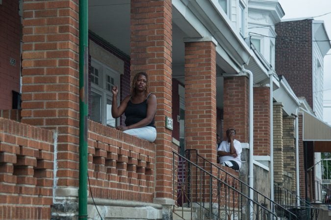 Neighbors gather from their porches to support the rally the bring justice for the death of Sandrea WIlliams who was shot to death outside of her mother’s home in West Philadelphia on May 11th, 2018. You can see the corner where she and two other boys were shot at from the porches that line the neighborhood. (Emily Cohen for WHYY)