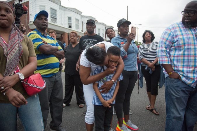 Sakinah Crew comforts her 7 year old son, Swyhir, during a rally to bring justice for the death of Sandrea Williams. She was killed in a random act of gun violence outside of her mother’s home in West Philadelphia. Their teenage cousin was also injured by gunfire that night. (Emily Cohen for WHYY)