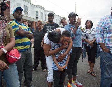 Sakinah Crew comforts her 7-year-old son, Swyhir, during a rally to bring justice for the killing of Sandrea Williams. She was killed in a random act of gun violence outside of her mother’s home in West Philadelphia. Their teenage cousin was also injured by gunfire that night. (Emily Cohen for WHYY)