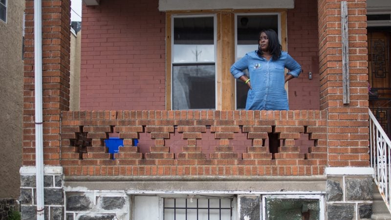 Tanya Parnell, or Miss Tee as the neighborhood kids call her, stands on her porch which is next to Sandrea Williams’ mother’s home and overlooks the corner in which the 17 year old girl was murdered in a random act of violence three weeks earlier. (Emily Cohen for WHYY)