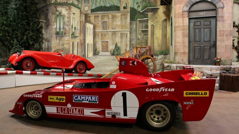 Alfa Romeo racers from 1937 and 1975 share the stage that evokes the streets of central Italy, where the Mille Miglia road race was held. (Emma Lee/WHYY)