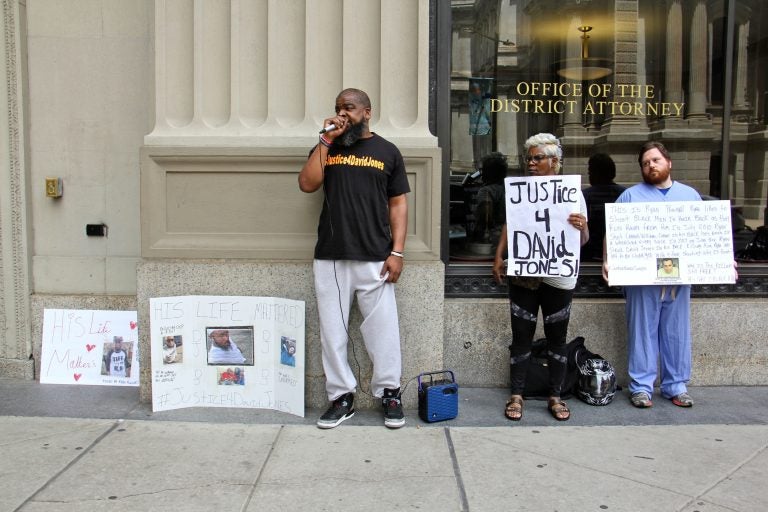 Isaac Gardner (left), of the Justice for David Jones Coalition, leads a small protest outside the district attorney's office calling for charges against Ryan Pownall, the Philadelphia police officer who fatally shot Jones during a traffic stop.