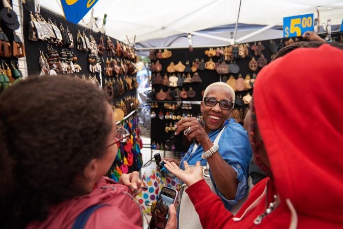 Belinda Adams of Cobbs Creek shops at Amy’s Earrings at the 2018 Odunde Festival. She has been coming to the festival for 10 years in search of handmade African jewelry, which she says is otherwise hard to find. (Natalie Piserchio for WHYY News) 