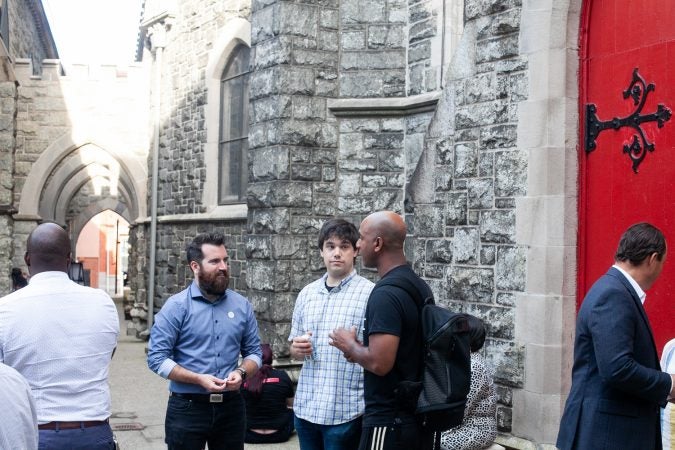 Guests gathered in the courtyard of the Church of The Advocate in North Philadelphia before Finding Sanctuary. (Brad Larrison for WHYY)