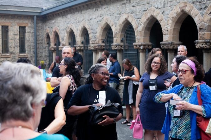 Guests gathered in the courtyard of the Church of The Advocate in North Philadelphia before Finding Sanctuary. (Brad Larrison for WHYY)