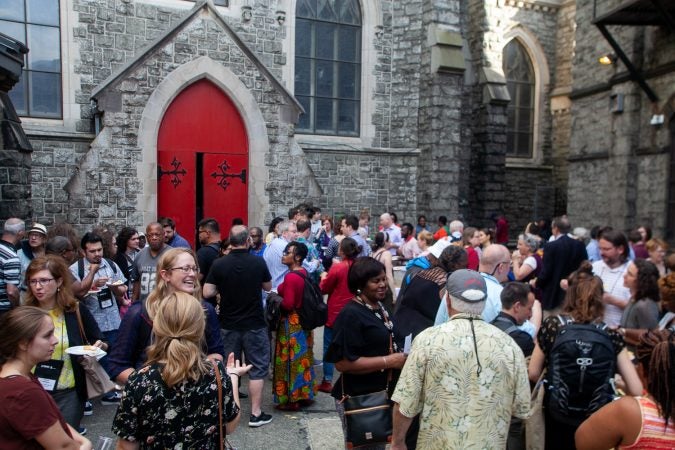 Guests gathered in the courtyard of the Church of The Advocate in North Philadelphia before Finding Sanctuary. (Brad Larrison for WHYY)