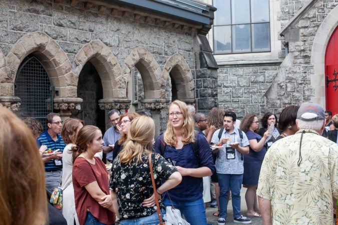 Guests gathered in the courtyard of the Church of The Advocate in North Philadelphia before Finding Sanctuary. (Brad Larrison for WHYY)