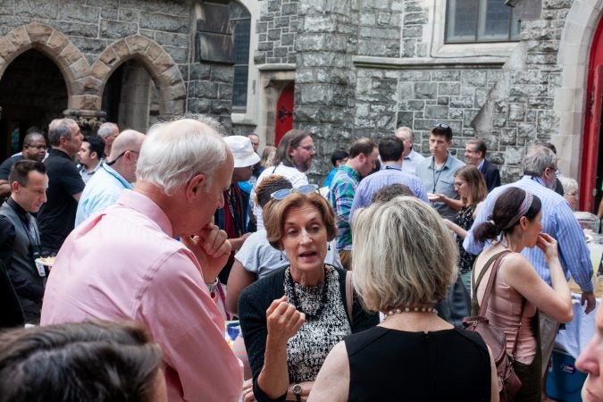Guests gathered in the courtyard of the Church of The Advocate in North Philadelphia before Finding Sanctuary. (Brad Larrison for WHYY)