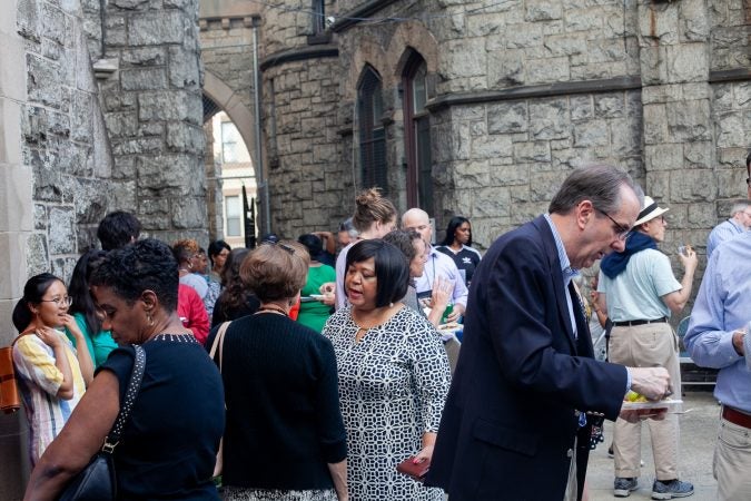 Guests gathered in the courtyard of the Church of The Advocate in North Philadelphia before Finding Sanctuary. (Brad Larrison for WHYY)