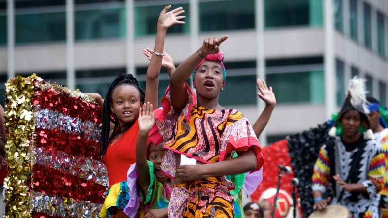 Juneteenth Parade participants wave from their float as they make their way through Center City in June 2018. (Bastiaan Slabbers for WHYY)