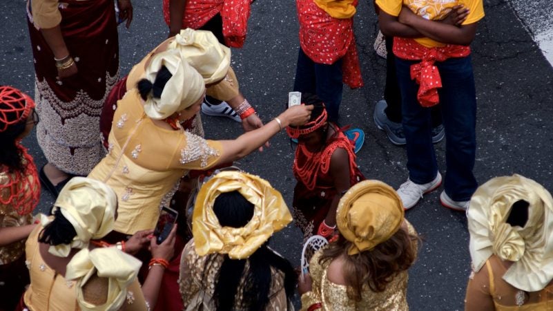 Dollar bills are placed on top of the head of a young dancer during the annual Juneteenth Parade, in Center City on Saturday. (Bastiaan Slabbers for WHYY)