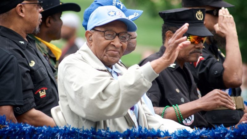 Tuskegee Airmen with the 332nd Fighter Group and the 477th Bombardment Group of the United States Army Air Forces wave to the crowd lining Independence Mall, during the annual Juneteenth Parade, on Saturday. (Bastiaan Slabbers for WHYY)