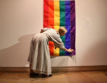 Philadelphia Museum of Art Assistant Curator Michelle Millar Fisher hangs a rainbow flag marking the 40th anniversary of the unfurling of the original at the Gay Freedom Day Parade in San Francisco on June 25, 1978. The flag was designed by Gilbert Baker, who referred to himself as the 