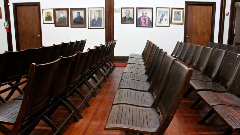 Former leaders of Wharton-Wesley United Methodist Church in Southwest Philadelphia line the walls of a small chapel shared with a Mennonite congregation. (Emma Lee/WHYY)