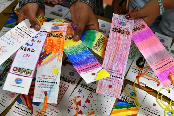 Alma, 11, and Yaretzy, 11, show some of the bookmarks they made at Mighty Writers El Futuro in South Philadelphia. (Bastiaan Slabbers for WHYY)