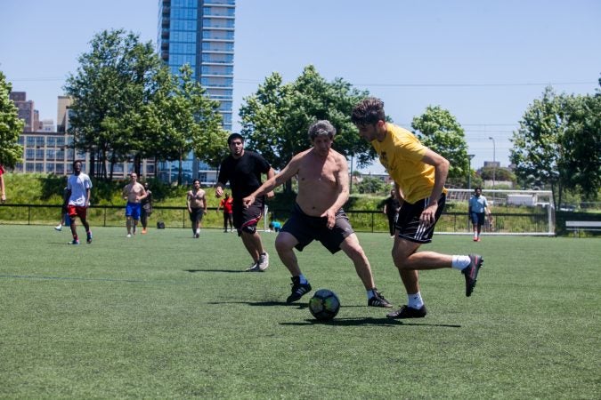 Players enjoy the weather and a pickup game Thursday. If Philadelphia were to be chosen as one of the host cities for the 2026 World Cup, matches would be played at Lincoln Financial Field. (Brad Larrison for WHYY)