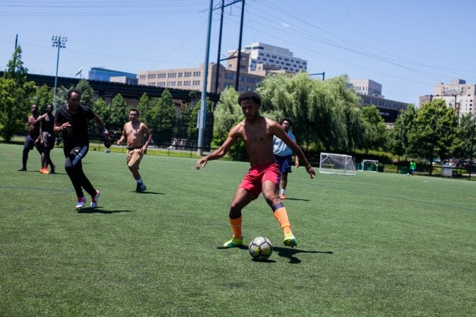 University of Pennsylvania students, workers, and community members play pickup soccer at Penn Park on June 14, 2018. Many were anticipating this year's World Cup tournament. (Brad Larrison for WHYY)