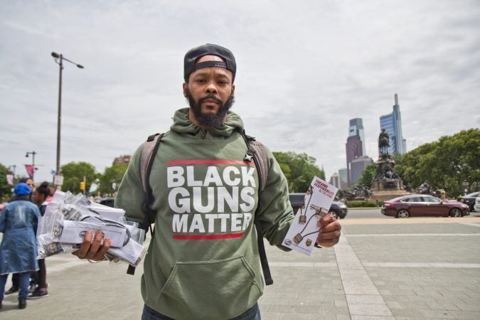 Maj Toure, leader of the organization Black Guns Matter, handed out firearm locks and pamphlets at the rally. (Kimberly Paynter/WHYY)