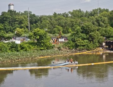 An environmental cleanup crew works to remove fuel from a spill in Darby Creek in Tinicum Township, Pennsylvania, near the Philadelphia International Airport. (Kimberly Paynter/WHYY)