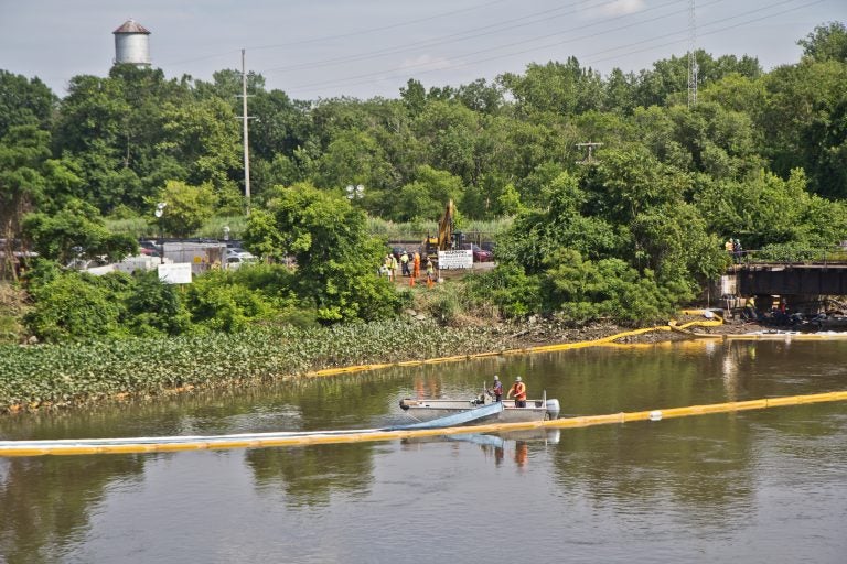 An environmental cleanup crew works to remove fuel from a spill in Darby Creek in Tinicum Township, Pennsylvania, near the Philadelphia International Airport. (Kimberly Paynter/WHYY)