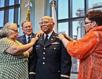 John Edward James Jr., an Army veteran of World War II, is pinned with the rank of second lieutenant by his daughters Brenda Roberta Watts (left) and Dr. Marion Teresa Lane. (Kimberly Paynter/WHYY)