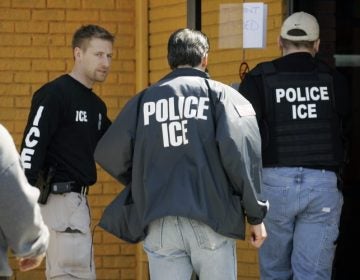 In this file photo, Immigration and Customs Enforcement agents enter a restaurant to remove evidence. (David Duprey/AP Photo)