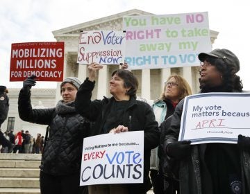 People rally outside of the Supreme Court in opposition to Ohio's voter roll purges, Wednesday, Jan. 10, 2018, in Washington.