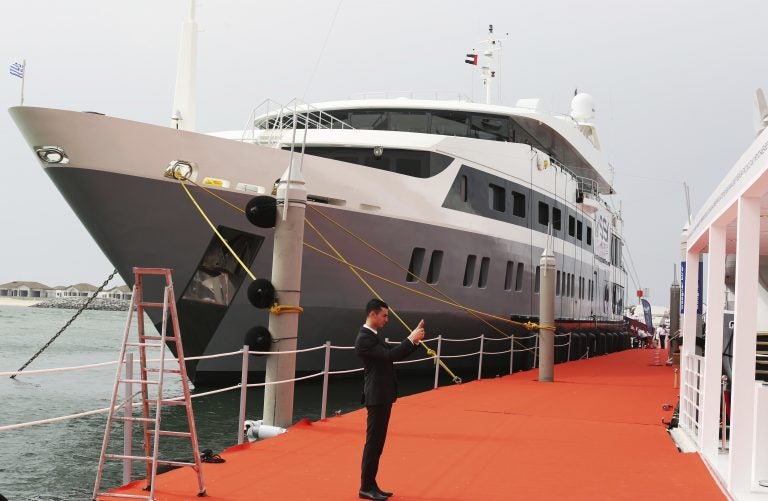 A salesman takes a picture of his stand in front of the 72-meter yacht Serenity in Dubai, United Arab Emirates, Tuesday, Feb. 27, 2018. The Dubai International Boat Show is being held from Tuesday to Saturday and features yachts costing into the hundreds of millions of dollars. (Jon Gambrell/AP Photo)