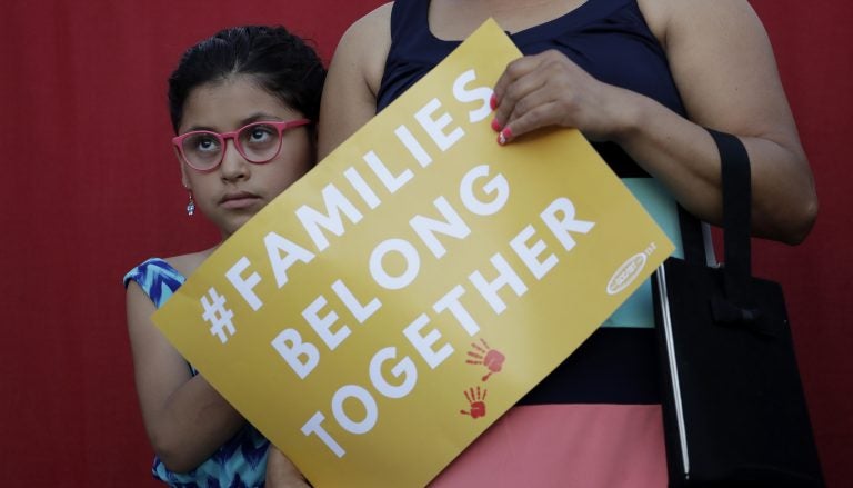 A girl stands with her mother during a Rally For Our Children event to protest a new 