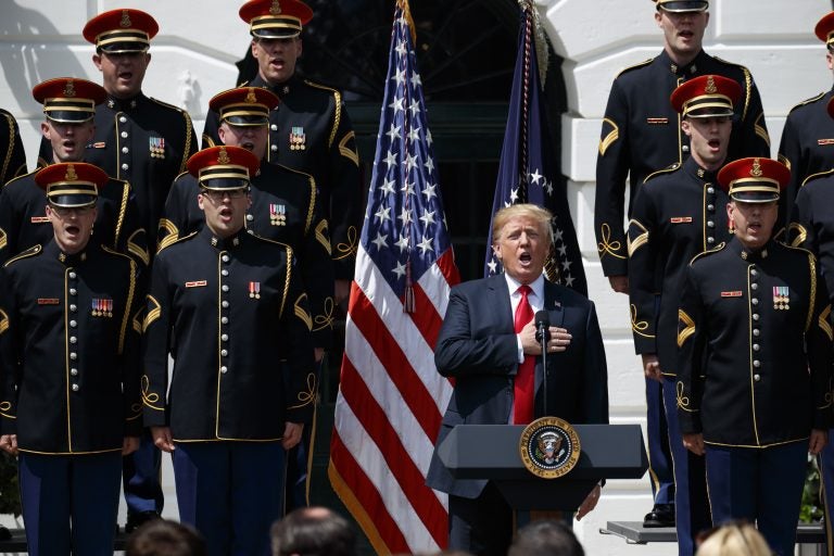 President Donald Trump sings the national anthem during a 