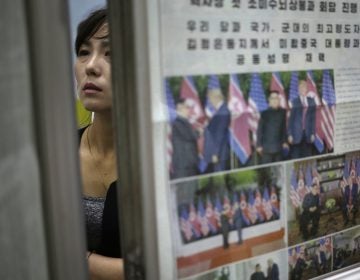 A woman reads newspapers fronting the news on President Donald Trump's summit with North Korean leader Kim Jong Un at Puhung subway station in Pyongyang, North Korea, Wednesday, June 13, 2018. The series of photos on the front page of the ruling workers' party newspaper showed something North Koreans never would have imagined just months ago — their leader Kim Jong Un warmly shaking hands with President Donald Trump. (Dita Alangkara/AP Photo)