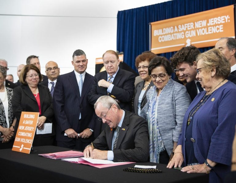 Gov. Phil Murphy signs several gun-safety bills at the Richard J. Hughes Justice Complex Atrium in Trenton Wednesday. The half-dozen new gun-control laws tighten the state's already strict statutes. (Edwin J. Torres/New Jersey Governor's Office via AP)