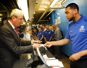 New Jersey Gov. Phil Murphy makes the first wager with Monmouth Park Sports Book ticket writer Quentin Harris, at Monmouth Park Racetrack Thursday in Oceanport, New Jersey. Major League Baseball has circulated a memo to teams, forbidding them and their broadcasting affiliates from accepting advertisements from sports betting outfits, such as Monmouth. (AP Photo/Noah K. Murray)