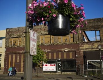 In this June 16, 2017, file photo, dilapidated storefronts stand along baskets of pink petunias that hang from light posts all over town, watered regularly by residents trying to make their city feel alive again in Aberdeen, Wash. From drivers paying more for gas and families bearing heavier child care costs to workers still awaiting decent pay raises to couples struggling to afford a home, people throughout the economy are straining to succeed despite the economy’s gains. (AP Photo/David Goldman, File)