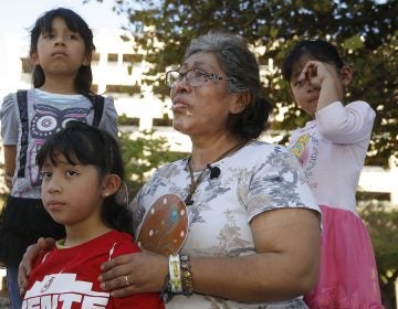 Lucia Ajas, middle, talks about her and her children, Regina Vargas, 7, left, Akemi Vargas, 8, second from left, and Trinidad Vargas, 5, right, being separated from their father during an immigration family separation protest in front of the Sandra Day O'Connor U.S. District Court building, Monday, June 18, 2018, in Phoenix.