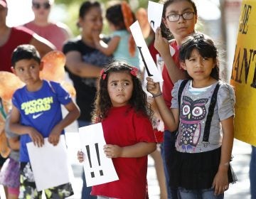 Children listen to speakers during an immigration family separation protest in front of the Sandra Day O'Connor U.S. District Court building, Monday, June 18, 2018, in Phoenix. An unapologetic President Donald Trump defended his administration's border-protection policies Monday in the face of rising national outrage over the forced separation of migrant children from their parents. (AP Photo/Ross D. Franklin)